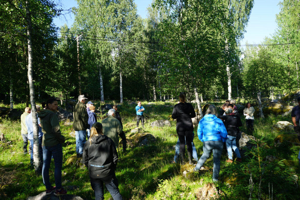 Människor som står i en cirkel och lyssnar på en person